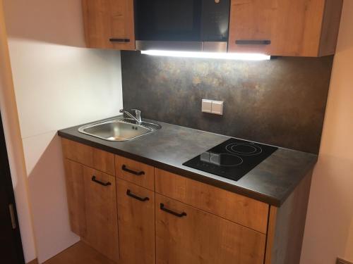 a kitchen with a sink and a stove at Parkhotel Leiser in Planegg