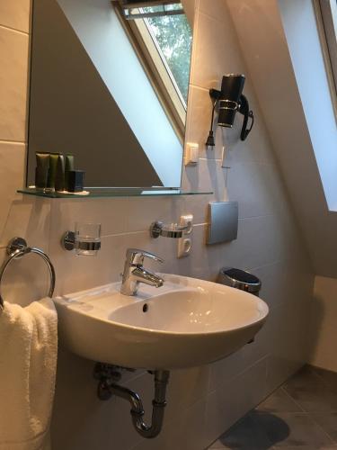 a bathroom with a sink and a mirror at Parkhotel Leiser in Planegg