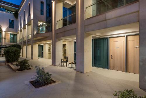 an empty courtyard of a building with a table and chairs at Trianon Luxury Apartments & Suites in Chania Town