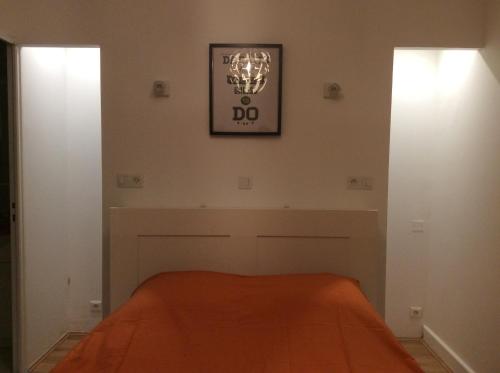 ヴィシーにあるAppartement au calme avec terrasseのベッドルーム1室(オレンジ色の毛布付きのベッド1台付)