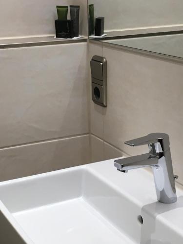 a bathroom sink with a faucet on a counter at Parkhotel Leiser in Planegg