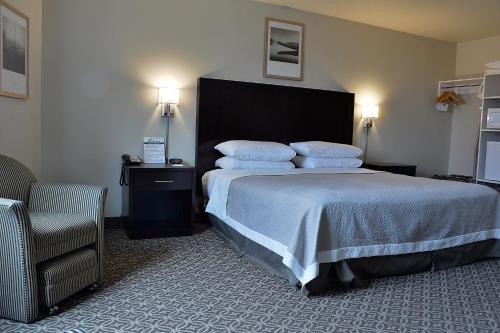 a hotel room with a bed with pillows and a chair at The Madison Inn in Spokane