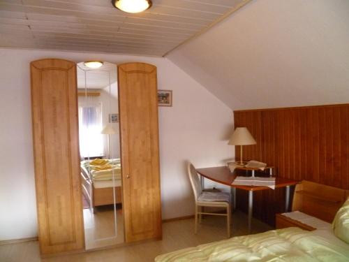 a bedroom with a bed and a desk and a table at Hotel Rotbuche in Westoverledingen