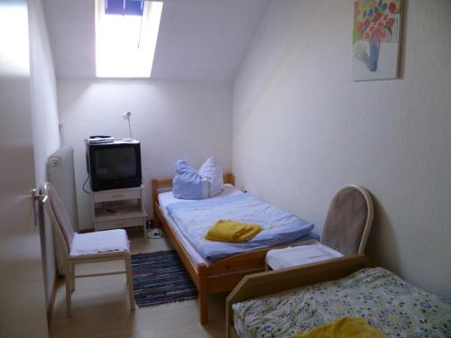 a small room with two beds and a tv at Hotel Rotbuche in Westoverledingen