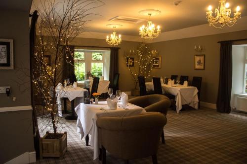 a dining room with tables and chairs and chandeliers at Greshornish House Hotel in Edinbane