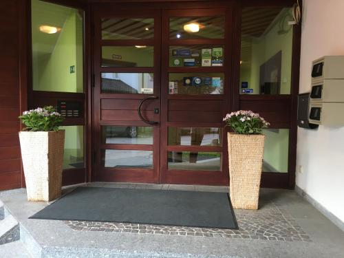 a front door of a building with two vases with flowers at Parkhotel Leiser in Planegg