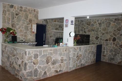 um balcão de pedra num quarto com uma parede de pedra em Hotel da Ilha Comprida em Ilha Comprida