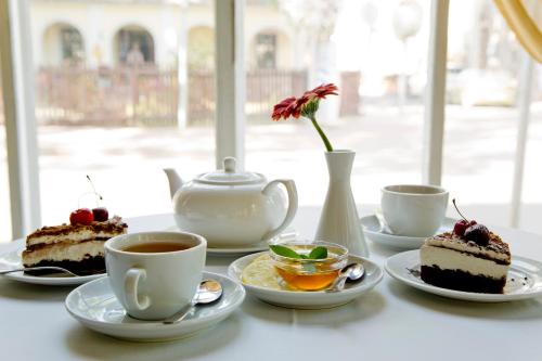a table with two cakes and cups of coffee at Hotel Victoria in Pärnu