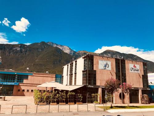 un grand bâtiment avec une montagne en arrière-plan dans l'établissement Fly Bike Hotel, à Trente