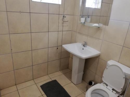 a bathroom with a toilet and a sink at Abendruhe Guest House in Eshowe