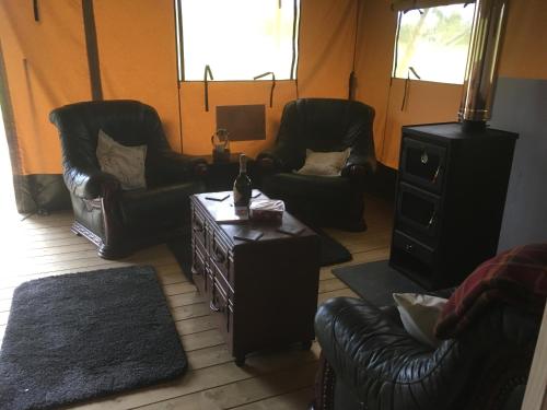 a living room with leather chairs and a table at Lincolnshire Glamping in Horncastle