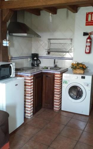 a kitchen with a washing machine and a washer at Apartamento Rural El Pino in Mogarraz