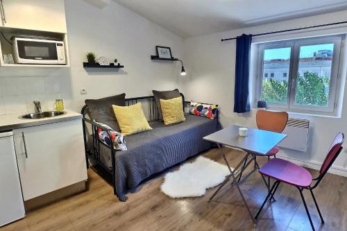 un petit salon avec un canapé et une table dans l'établissement Les Appartements d'Edmond Sylvabelle, à Marseille