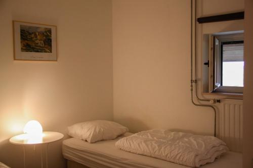 a small bedroom with a bed and a lamp at Hoeve "doodleger" in Vijlen