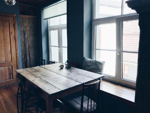 drewniany stół w pokoju z 2 oknami w obiekcie The Heart of Old Riga w Rydze