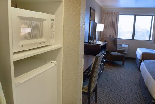 a hotel room with a microwave and a bedroom at Riversage Billings Inn in Billings