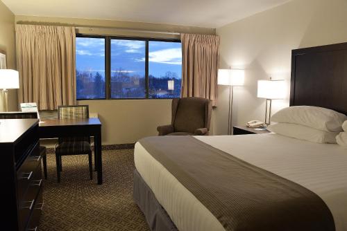 ein Hotelzimmer mit einem Bett, einem Schreibtisch und einem Fenster in der Unterkunft Riversage Billings Inn in Billings