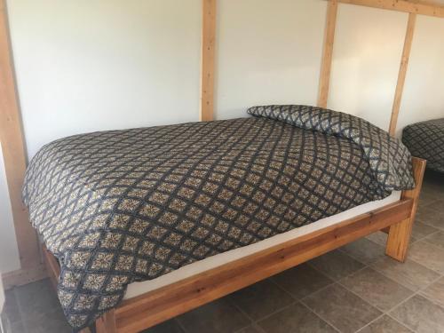 a bed in a room with a wooden frame at Lake Louise Lodge, Alaska in Glennallen