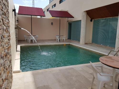 a swimming pool with a fountain in a building at Hotel Boutique La Toja Campeche in Campeche