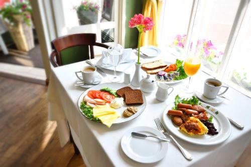 a white table with plates of food on it at Hotel Victoria in Pärnu