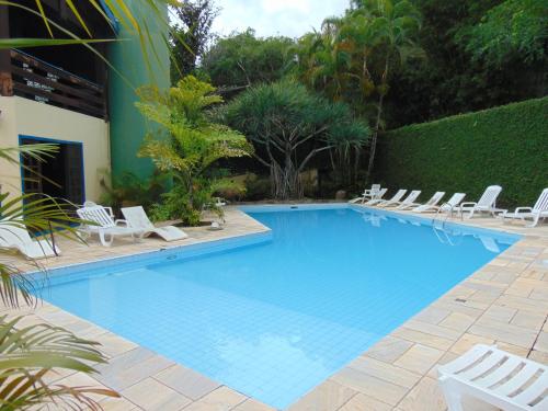 巴拉－沙希的住宿－Casa em condomínio，一个带白色椅子和树 ⁇ 的大型游泳池