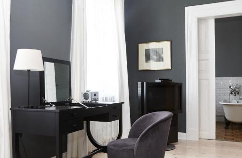 a desk with a mirror and a chair in a room at Historisches Bauernhaus Fehmarn in Strukkamp auf Fehmarn