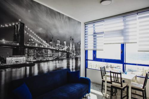 a living room with a blue couch and a city mural at Ashdod Beach Hotel in Ashdod