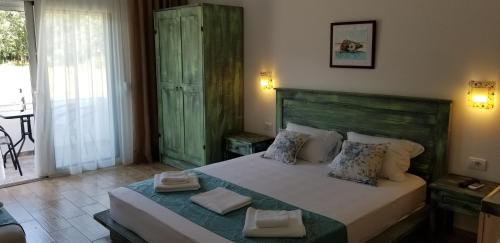 a bedroom with a large bed with a green headboard at Riviera Inn apartments in Ulcinj