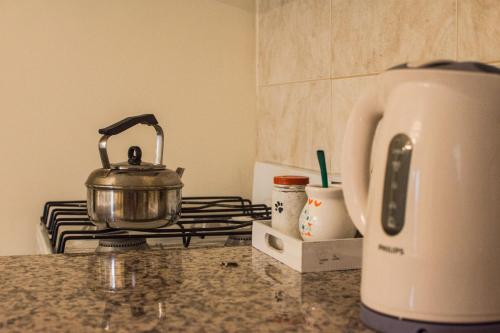 a tea kettle sitting on top of a stove at Departamento Temporario Bahia Blanca in Bahía Blanca