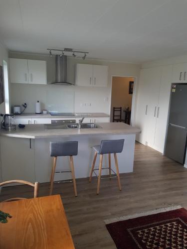 a kitchen with two chairs and a counter top at Garden Retreat in Otaki