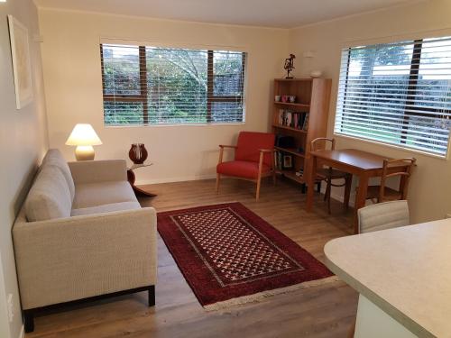 a living room with a couch and a table at Garden Retreat in Otaki