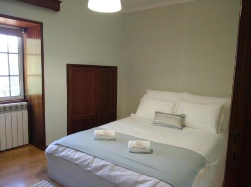 a bedroom with a bed with two towels on it at Quinta d'Areda Wine&Pool Experience in Fafe
