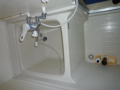 a shower with a hose in a white bathroom at Futami Terrace C in Ise