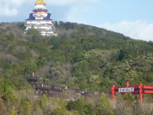 a building on top of a hill with a train at Futami Terrace C in Ise