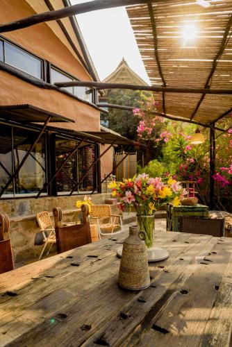a wooden table with a vase of flowers on it at Las Cabañas de Tarii in Cieneguilla