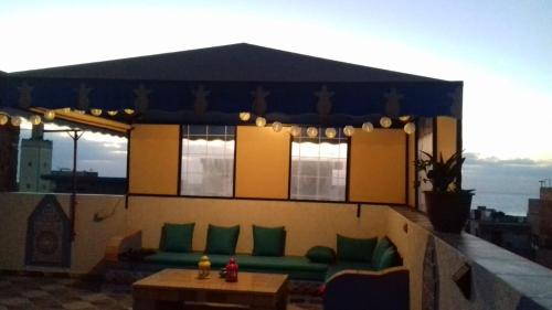 eine Terrasse mit einem Sofa und einem Tisch auf einem Gebäude in der Unterkunft luxury apartments in Asilah