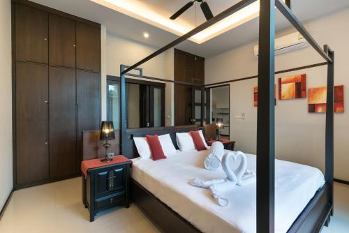 a bedroom with a bed with two white towels at Two bedrooms pool villa at Saiyuan estate in Rawai Beach