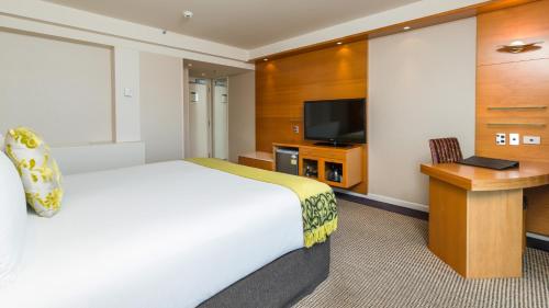 a hotel room with a bed and a television at Millennium Hotel Rotorua in Rotorua