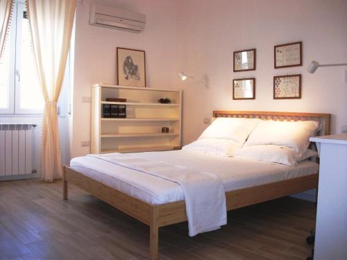 a bedroom with a large bed with white sheets at Bright apartment in Cagliari