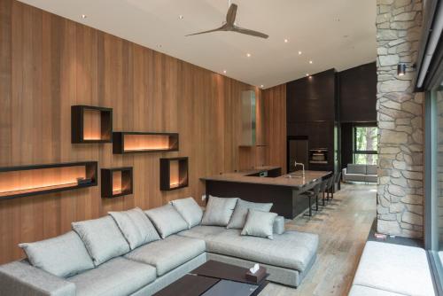 a living room with a couch and a kitchen at Villa El Cielo Hakuba in Hakuba