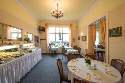 Un comedor con mesas y sillas y un restaurante. en Hotel Knöpel, en Wismar