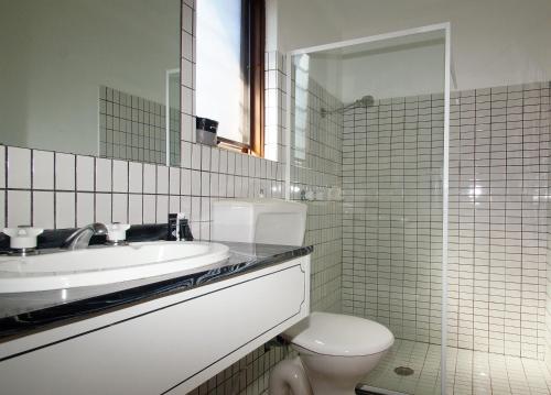 a bathroom with a sink and a toilet and a mirror at Seaton Arms Motor Inn in Albury