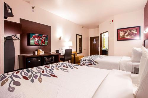 Habitación de hotel con 2 camas y escritorio en Seasons Inn Traverse City, en Traverse City