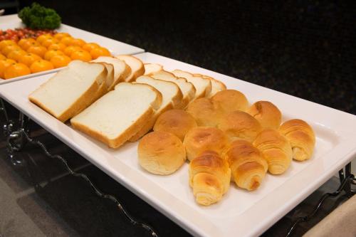 a white plate with bread and buns on a table at Hotel Mate Bundang in Seongnam