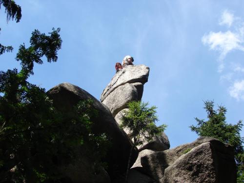 a person sitting on top of a large rock at Na Sluneční Pohádková chaloupka ve Sladké díře in Příchovice