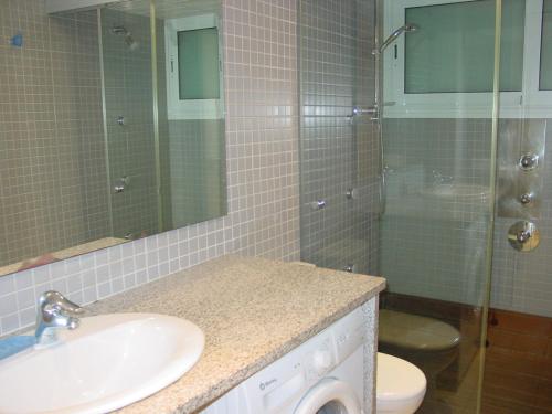 uma casa de banho com um lavatório, um WC e um chuveiro em Apartamentos Rodamar em L'Estartit