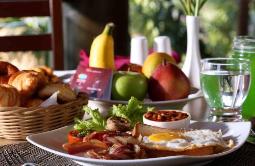 a table with two plates of food and a basket of fruit at Uday Samudra Leisure Beach Hotel & Spa in Kovalam