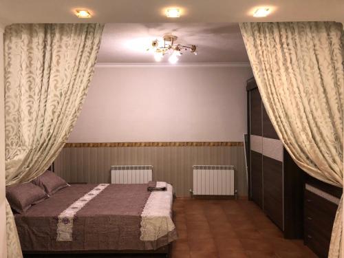 ウラジカフカスにあるТрехкомнатная Квартираのベッドルーム(ベッド1台、カーテン付)