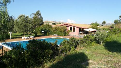 a swimming pool in front of a house at Agriturismo Colle del Sindaco in Petrizia