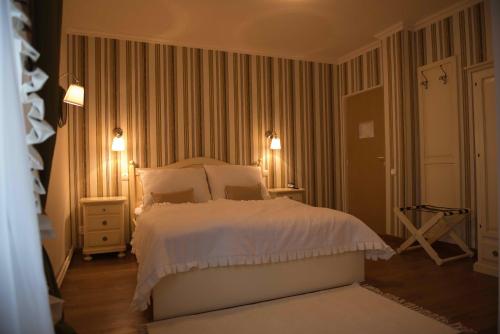 a bedroom with a bed with white sheets and lights at Boutique Vila Paradis in Deva